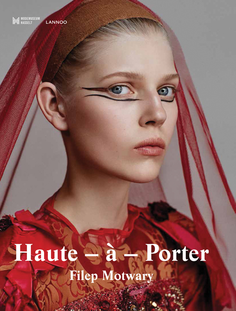 Fashion model with long black eyeliner, wearing a red veil to back of head, on cover of 'Haute-à-Porter, Haute-Couture in Ready-To-Wear Fashion', by Lannoo Publishers.