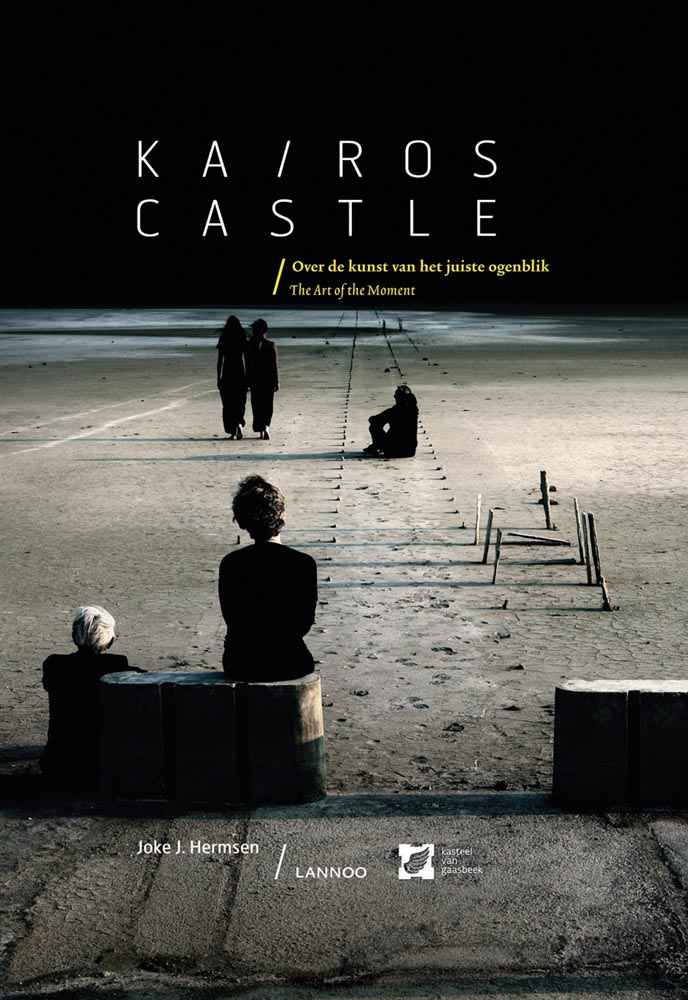 Figures standing apart on a sandy beach, at night, on cover of 'Kairos Castle, Art of the Moment', by Lannoo Publishers.