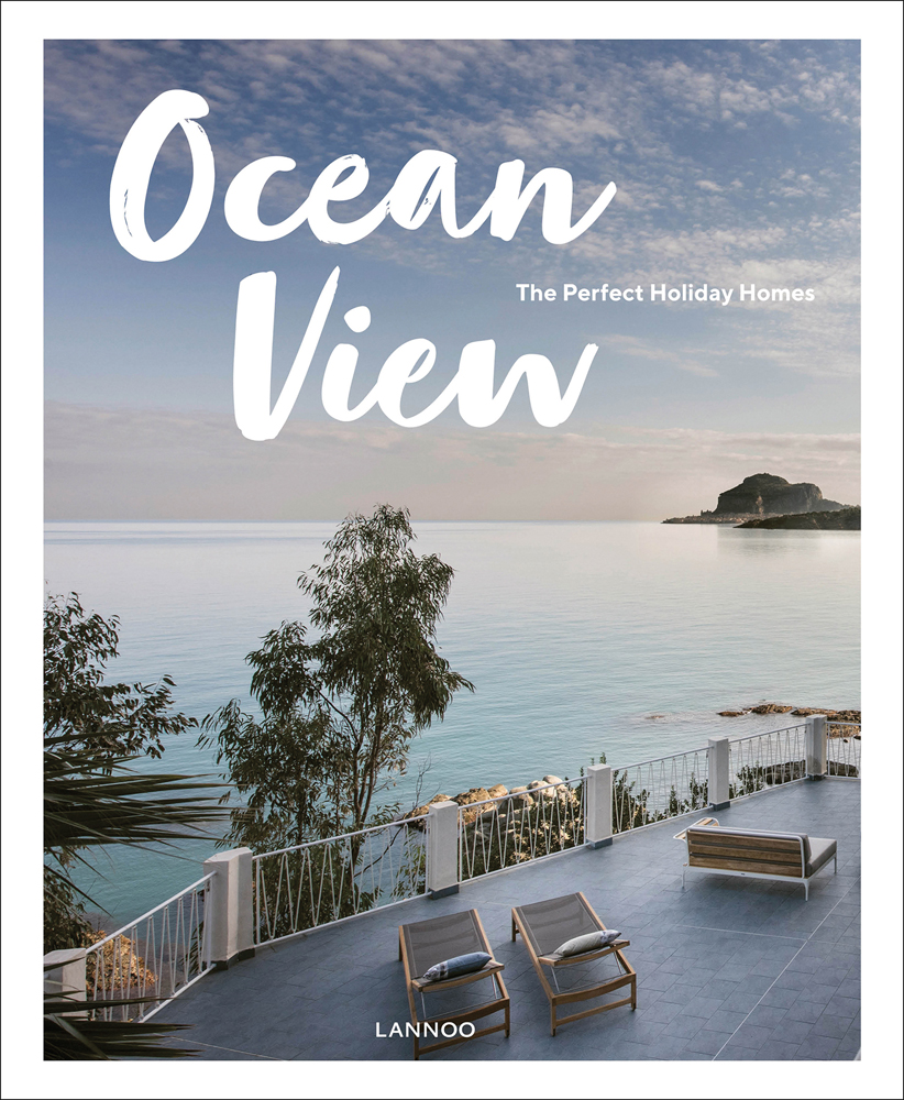 Holiday home with trees, looking out to seascape, deckchairs below, Ocean View in white font