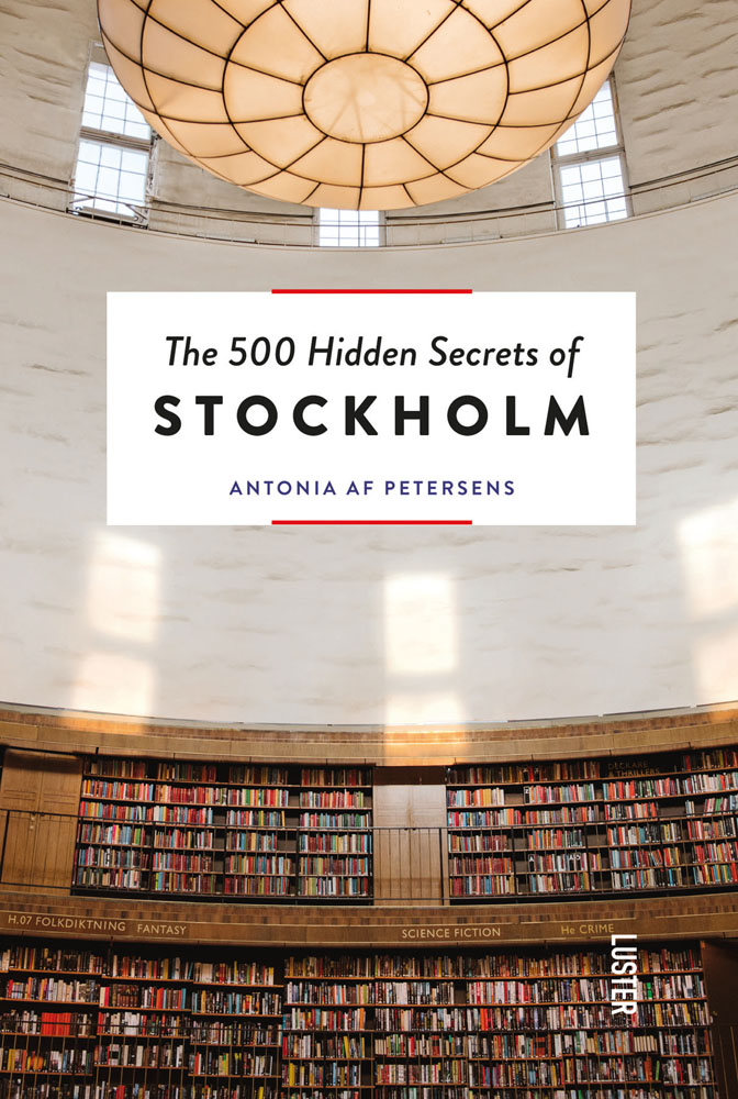 Shelving full of books in Stockholm public library, large light above, on cover of 'The 500 Hidden Secrets of Stockholm', by Luster Publishing.