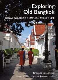 Buddhist monks in Thailand walking under trees on residential street, on cover of 'Exploring Old Bangkok', by River Books.