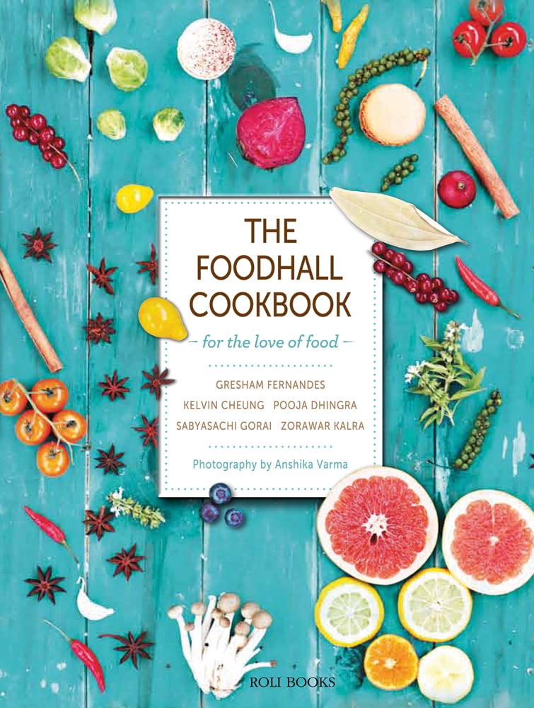 Grapefruit, sprouts, tomatoes, chillies, star anise on turquoise wood cover, The Foodhall Cookbook in brown font on white central banner