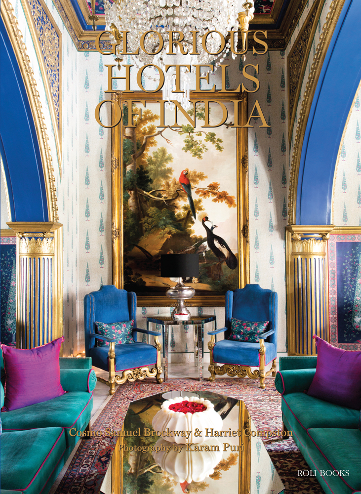 Luxurious hotel interior, brightly coloured sofas, glass chandelier above, GLORIOUS HOTELS OF INDIA in gold font above.