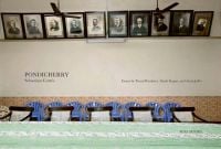 Book cover of Pondicherry, featuring a room with a long table, and old portrait photographs behind. Published by Roli Books.