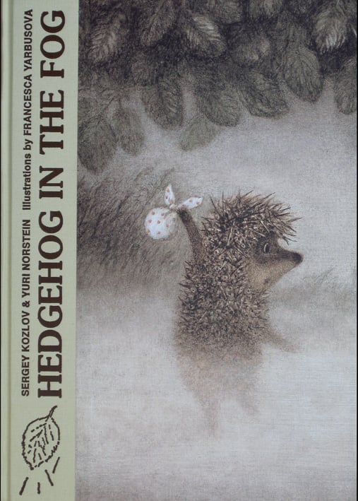 Hedgehog holding polka dot sack, walking through foggy forest, HEDGEHOG IN THE FOG in brown font down olive green left border.