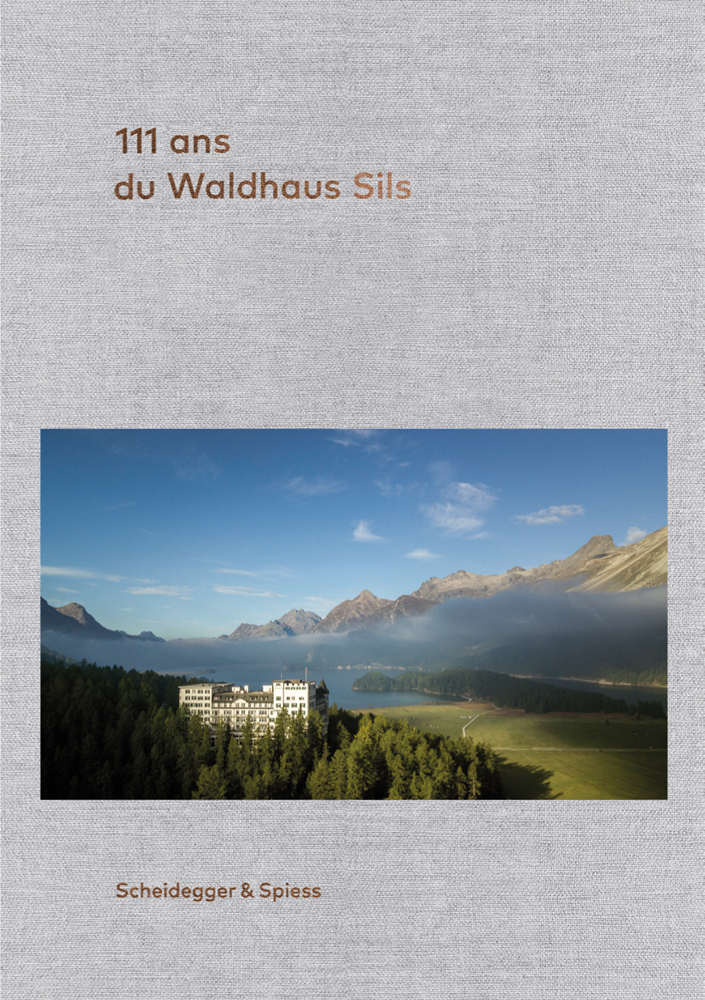The Waldhaus Sils hotel in breathtaking alpine landscape, on grey woven cover, 111 ans de l’Hotel Waldhaus Sils in gold font above.