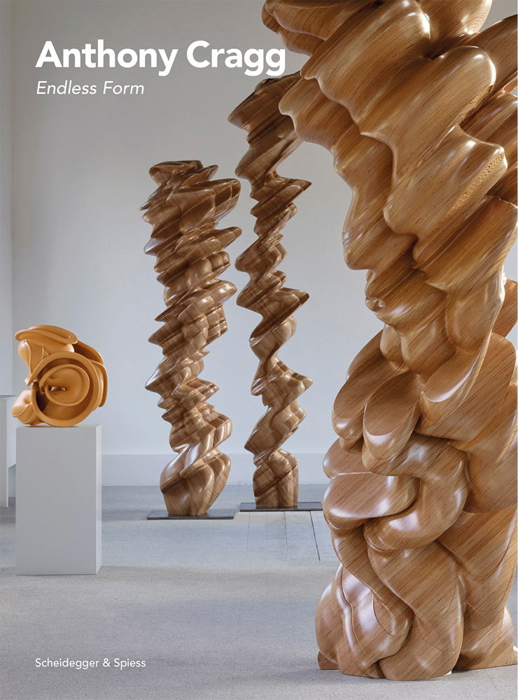 Tall curved wood sculptures in exhibition space, Anthony Cragg Endless Form in white font to upper left