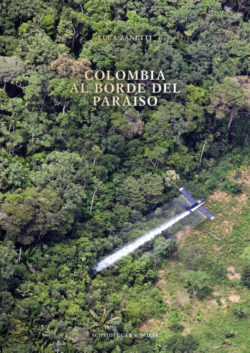 Aerial shot of light aircraft skimming over lush green landscape, COLOMBIA AL BORDE DEL PARISO in pale gold font above