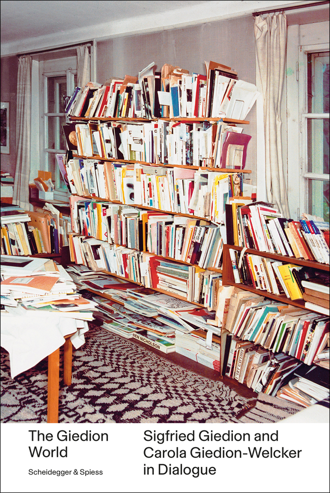 Bookshelf and table full of books and papers, The Giedion World Siegfried Giedion and Carola Giedion-Welcker in Dialogue in black font on bottom white banner