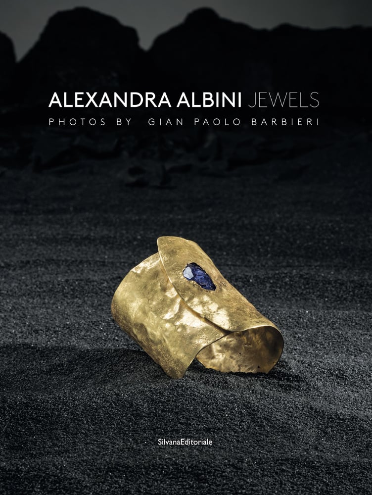 Book cover of Alexandra Albini: Jewels, with a hammered gold cuff bracelet with blue jewel to top. Published by Silvana.