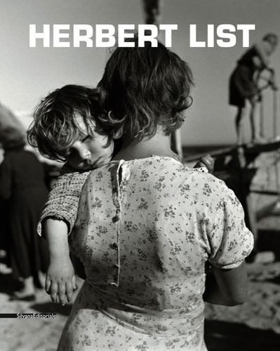 Back of women in floral dress, sleeping toddler on shoulder, HERBERT LIST in white font above