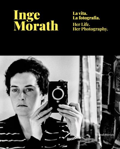 Self portrait photograph of Inge Morath holding camera, Inge Morath in black font to upper left.