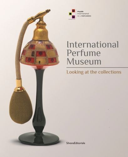 Elegant lamp-like perfume bottle with pump, off white cover, International Perfume Museum Looking at the Collections in grey and gold font right