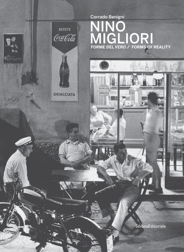Black and white shot, People of Emilia, Emilia-Romagna 1959, 3 males seated outside café with motorcycle, NINO MIGLIORI in white font to top right.