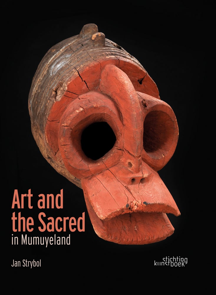Carved wood head with large holes for eyes and blunt beak, on black cover, Art and the Sacred in Mumuyeland in coral and white font to lower left