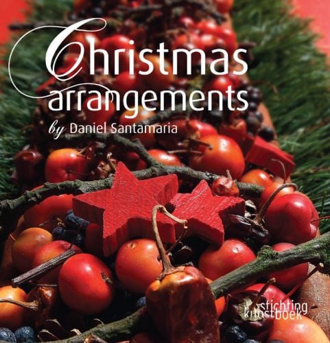 Book cover of Christmas Arrangements by Daniel Santamaria, with a table centrepiece made of red cherries, red stars, twigs and green foliage. Published by Stichting.