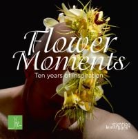 Book cover of Flower Moments, Ten Years of Inspiration, with the bald head of a man with white and yellow flower arrangement on top. Published by Stichting.