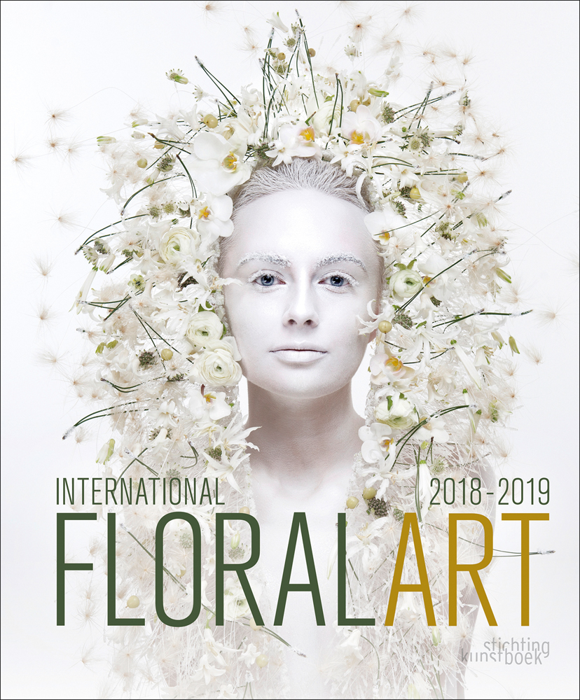Head-dress of white flowers cascading down sides of white face of model, on white cover, International Floral Art 2018/2019 in dark green and mustard font