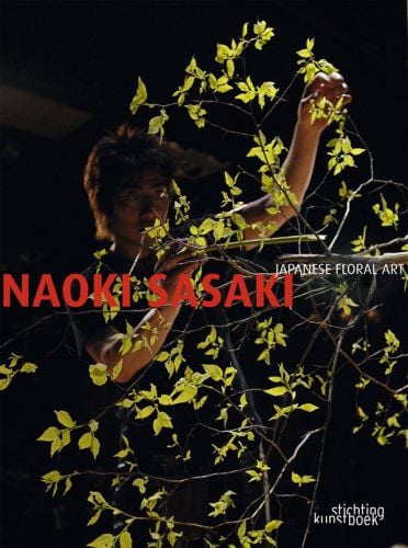 Book cover of Naoki Sasaki, Japanese Contemporary Floral Art, with Japanese artist moving the branches of a sparsely leaved tree. Published by Stichting.