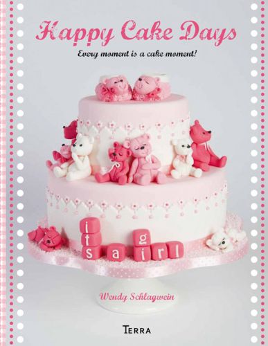Colour photograph of a two tiered pink and white baby it's a girl cake with sugar paste teddy bear figures and Happy Cake Days in pink