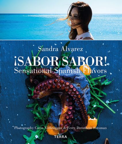 Sandra Alvarez, sea behind, aerial view of octopus with blue foam on slate below, on cover of 'Sandra Alvarez Sensational Spanish Flavors', by Lannoo Publishers..