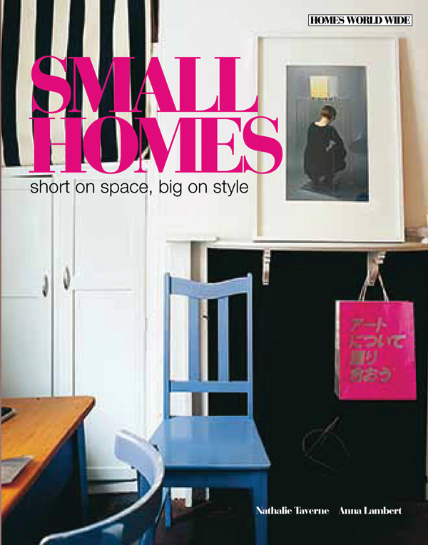 Colour photograph of an interior space featuring a blue wooden chair white cupboards a desk and a framed art print on the wall with Small Homes in pink and short on space, big on style in black