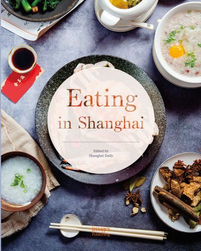 Large crab on plate, with bowls of dipping sauces, chopsticks, Eating in Shanghai stencilled out on transparent white circle in centre