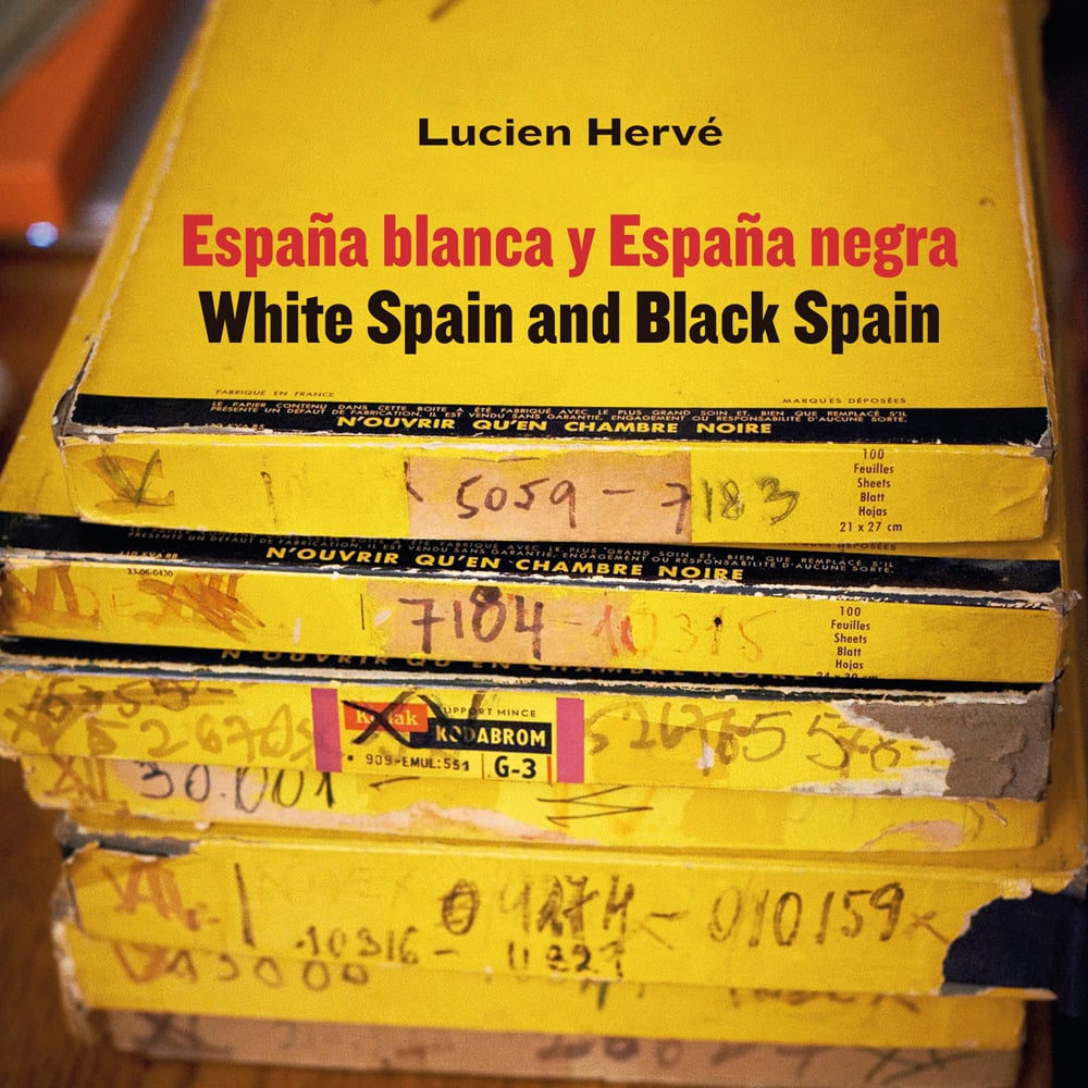 Stack of battered yellow film boxes, covered in tape and marker pen, Lucien Herve White Spain and Black Spain in black font above.