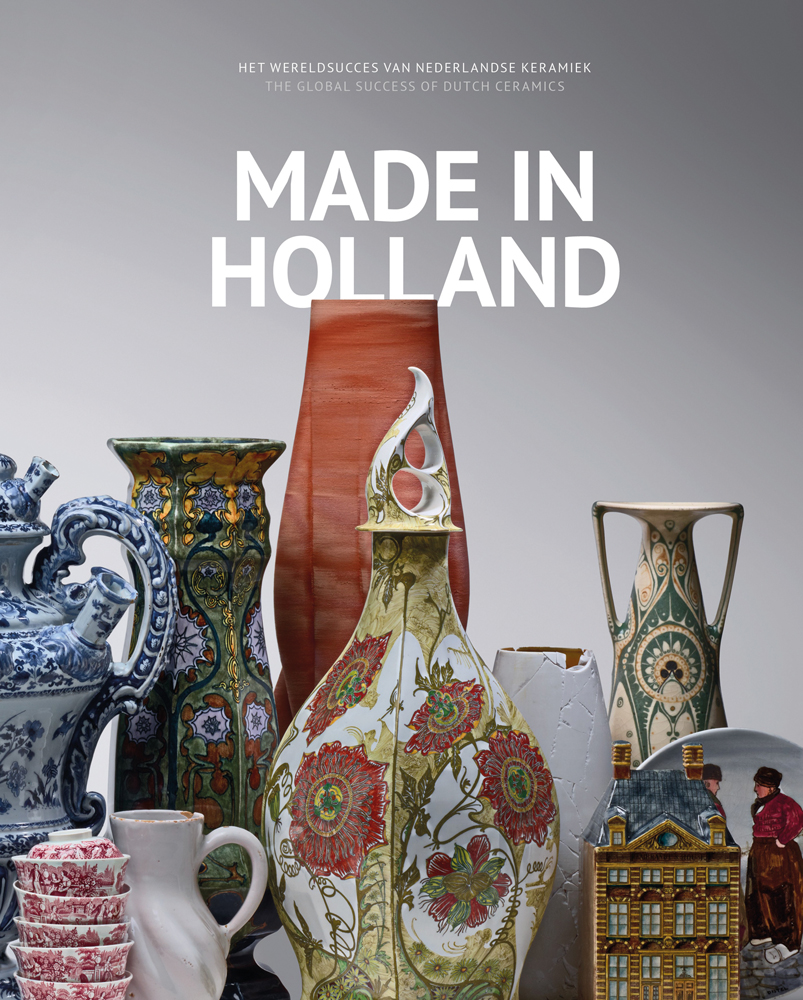 Collection of Dutch ceramic vessels, painted with flowers, on grey cover, Made in Holland in white font to centre