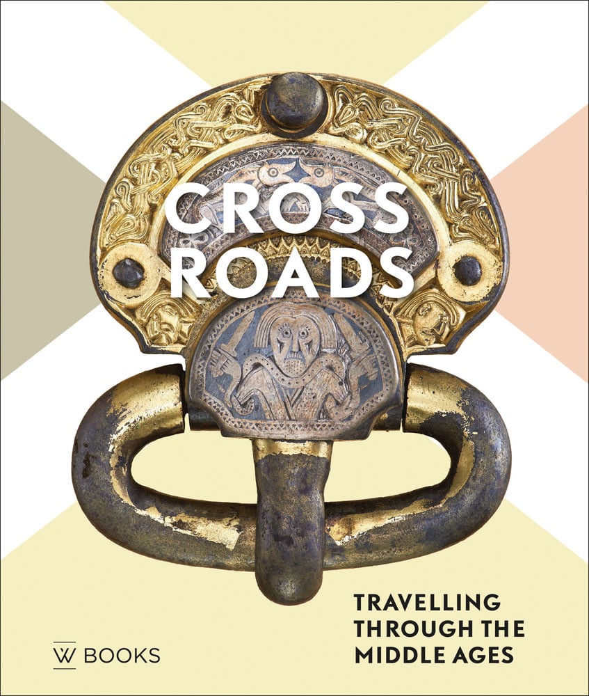 Gold and bronze metalwork shaped like door knocker, Crossroads in white font, Travelling Through the Middle Ages in black