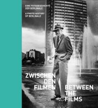 Book cover of Between the Films, A Photo History of the Berlinale, with James Stewart in suit and trilby, standing near water fountains with high-rise behind. Published by Verlag Kettler.