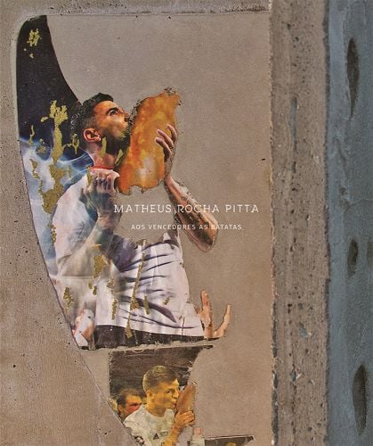 Book cover of Matheus Rocha Pitta, For the Winners the Potatoes, with painting on wall of man kissing a large potato. Published by Verlag Kettler.