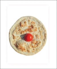 White book cover of Pizza is god, with a circular pizza with small, red tomato to center. Published by Verlag Kettler.