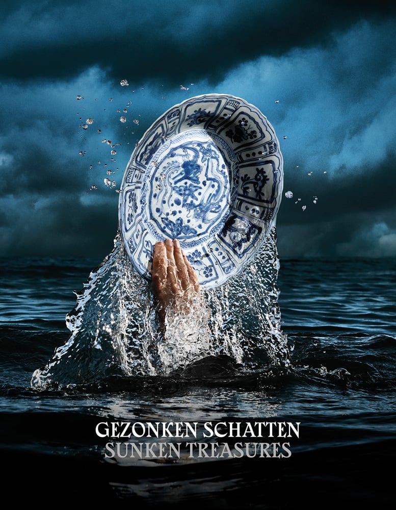 Hand shooting out of sea holding Chinese blue and white porcelain dish, GEZONKEN SCHATTEN SUNKEN TREASURES in white and grey font below.