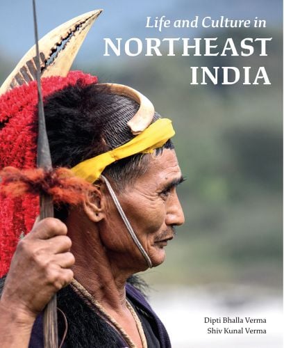 Tribesman red fabric and bone headdress, holding long object, Life and Culture in NORTHEAST INDIA in white font above.