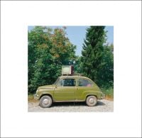 Book cover of Olivo Barbieri's Early Works: 1980 - 1984, with a green Fiat 500 with a T.V strapped to the roof, large green trees behind. Published by L'Artiere.