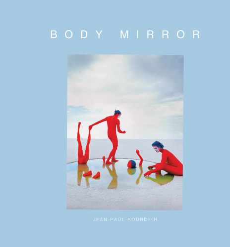 2 nude figure in red body paint and blue hair, 1 standing holding mannequin's legs, 1 sitting on edge of circular pool, blue cover, BODY MIRROR in white font above.