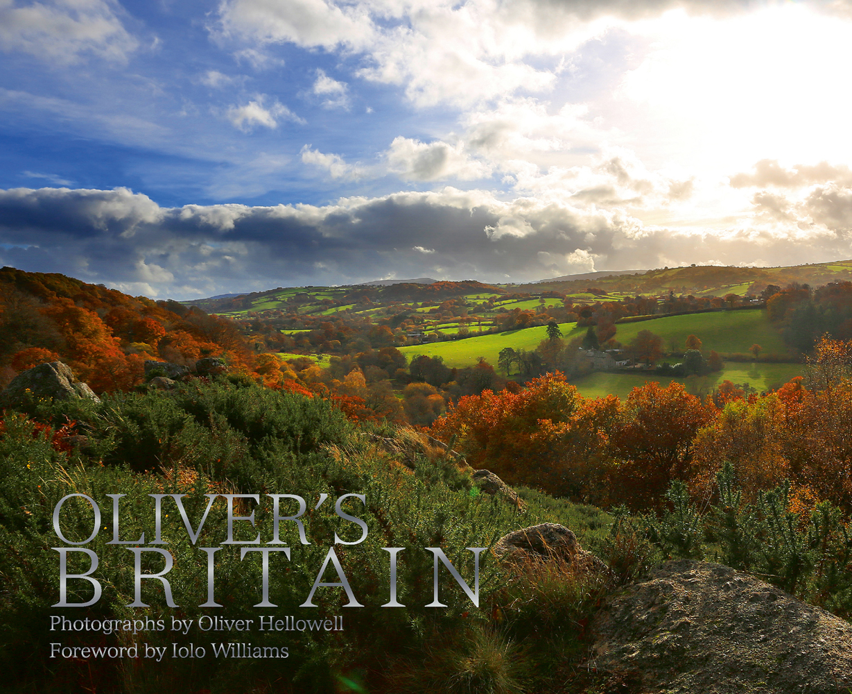 Hilly British landscape with blue cloudy sky above, on cover of 'Oliver's Britain', by ACC Art Books.