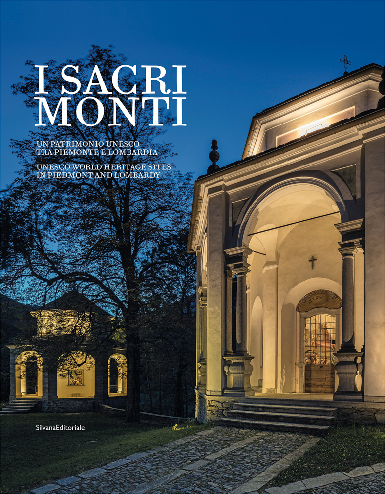 Illuminated front of one of the Chapels of The Sacri Monti, under night sky, I SACRI MONTI in white font to upper left.