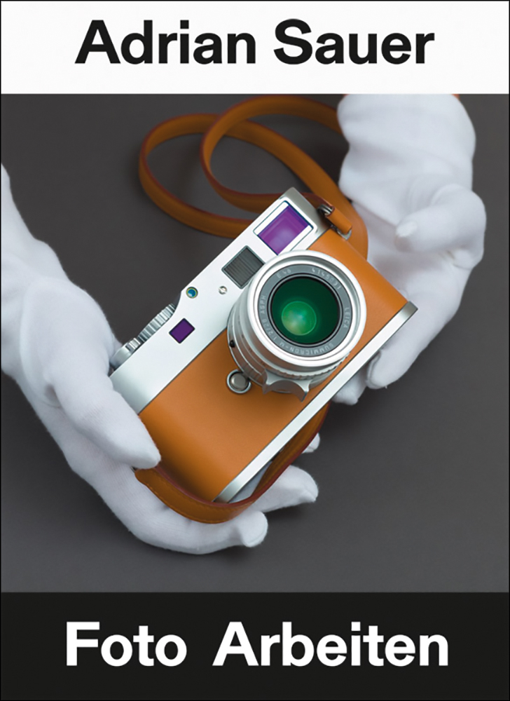 Book cover of Adrian Sauer: Foto Arbeiten / Photo Works, with a tan coloured compact SRL camera held by white gloved hands. Published by Kerber.