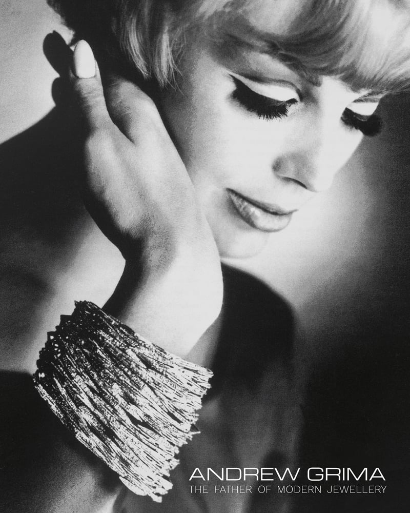 Fashion model wearing large bangle, hand to cheek, ANDREW GRIMA The Father of Modern Jewellery in white font to bottom right.