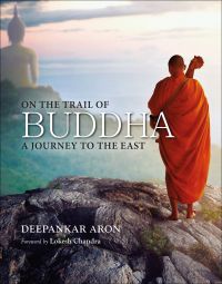 Book cover of On the Trail of Buddha: A Journey to the East, with a Buddhist monk standing near the edge of a cliff. Published by Niyogi Books.