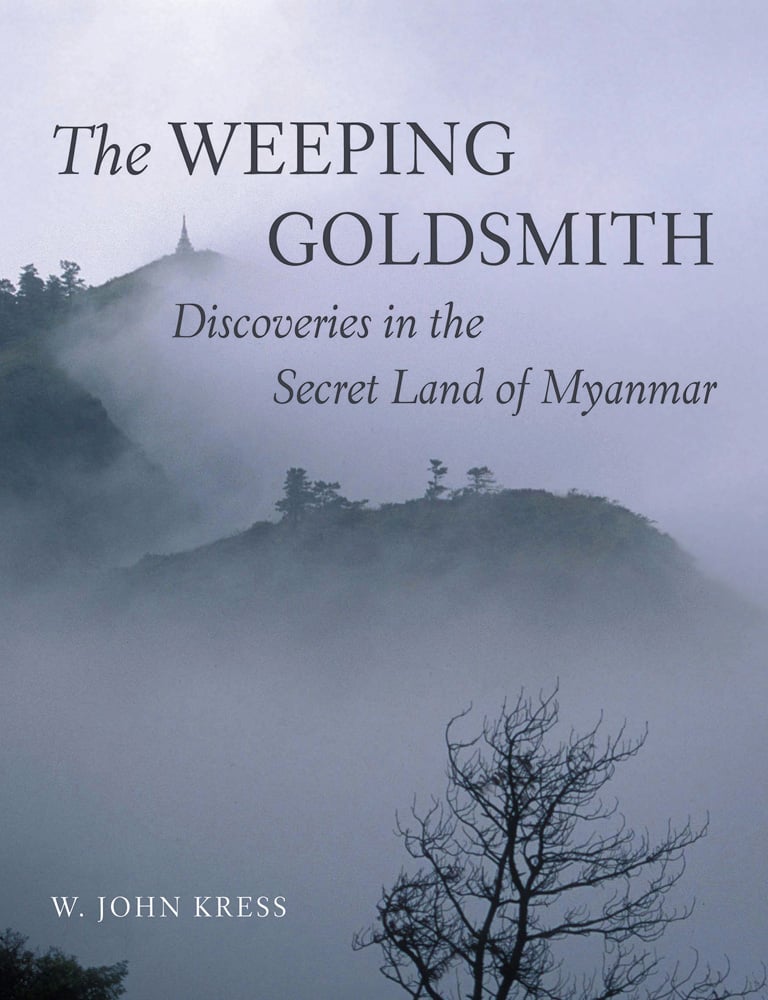 Misty mountainous landscape of Myanmar, silhouettes of trees, The WEEPING GOLDSMITH Discoveries in the Secret Land of Myanmar in black font above.