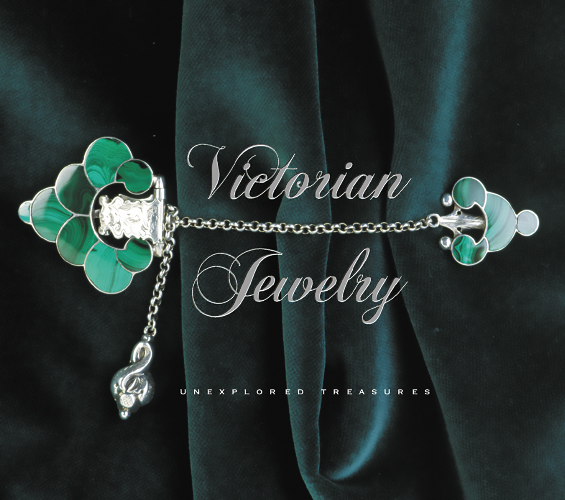 Green stone pin brooch with silver chain, pinned to dark green velvet, Victorian Jewelry in silver font to centre.