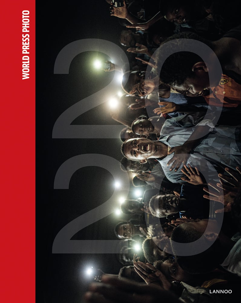 Group of young black males, front man talking, others clapping around him, on cover of 'World Press Photo 2020', by Lannoo Publishers.