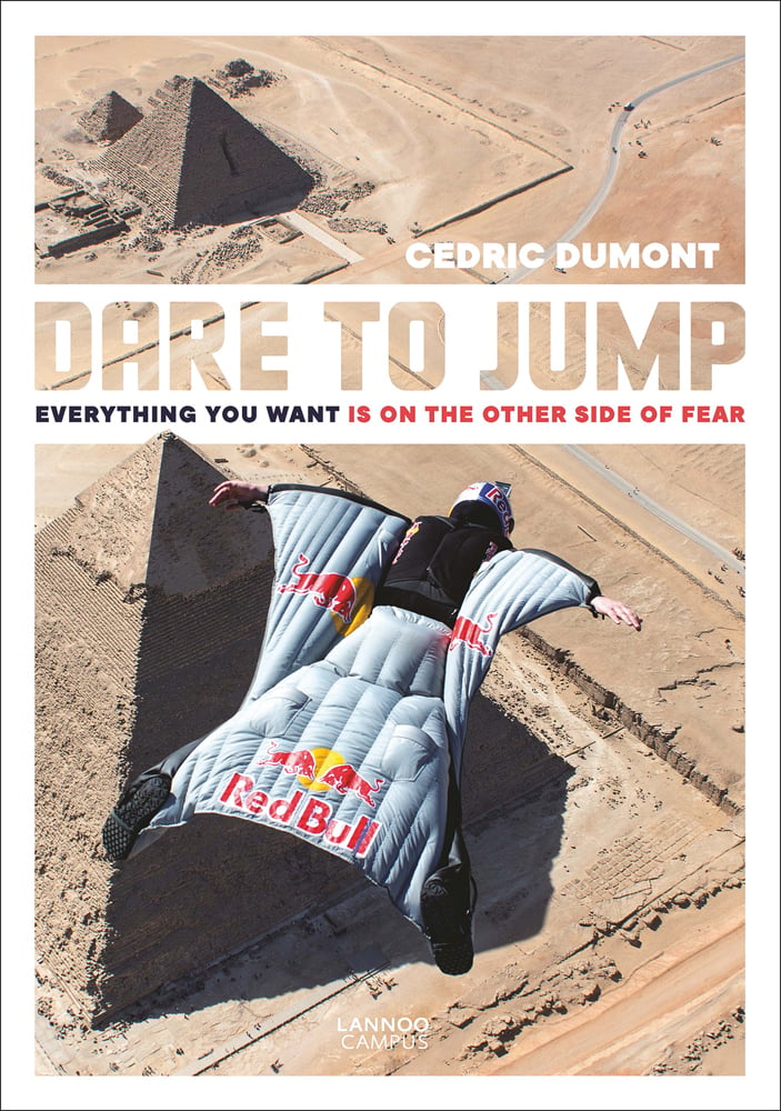 Skydiver in Red Bull wingsuit, gliding high up over Pyramids, on cover of 'Dare to Jump, Everything You Want is on the other Side of Fear', by Lannoo Publishers.