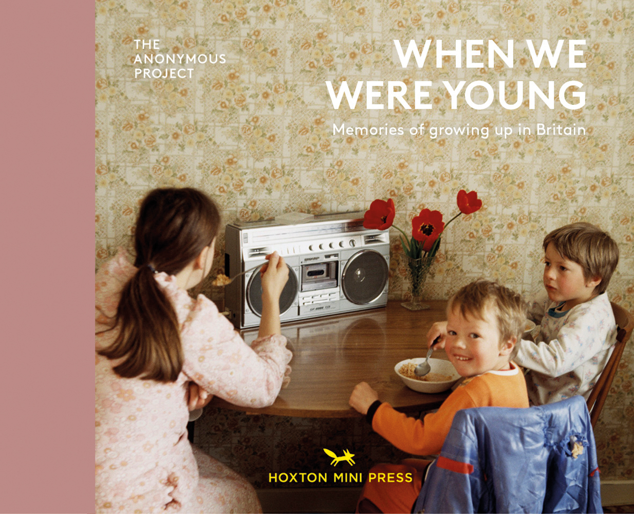 Three white young children sitting at round table eating cereal, with ghetto plaster, on landscape cover of 'When We Were Young, Memories of growing up in Britain', by Hoxton Mini Press.