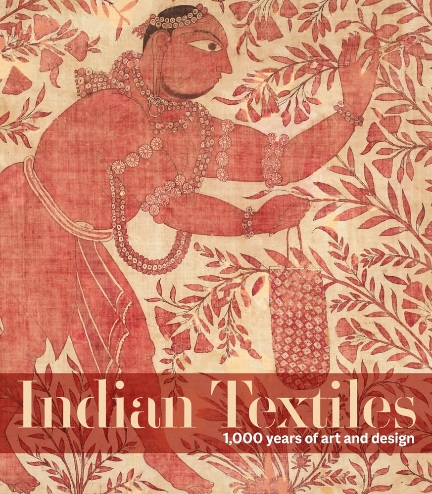 Light red and cream textile print with figure in traditional dress picking flowers from tree with Indian Textiles in cream font on red banner below