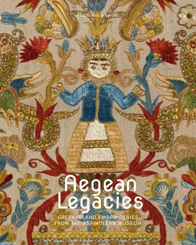 Vibrant Greek embroidery of figure with gold crown surrounded by flowers with Aegean Legacies in white font below
