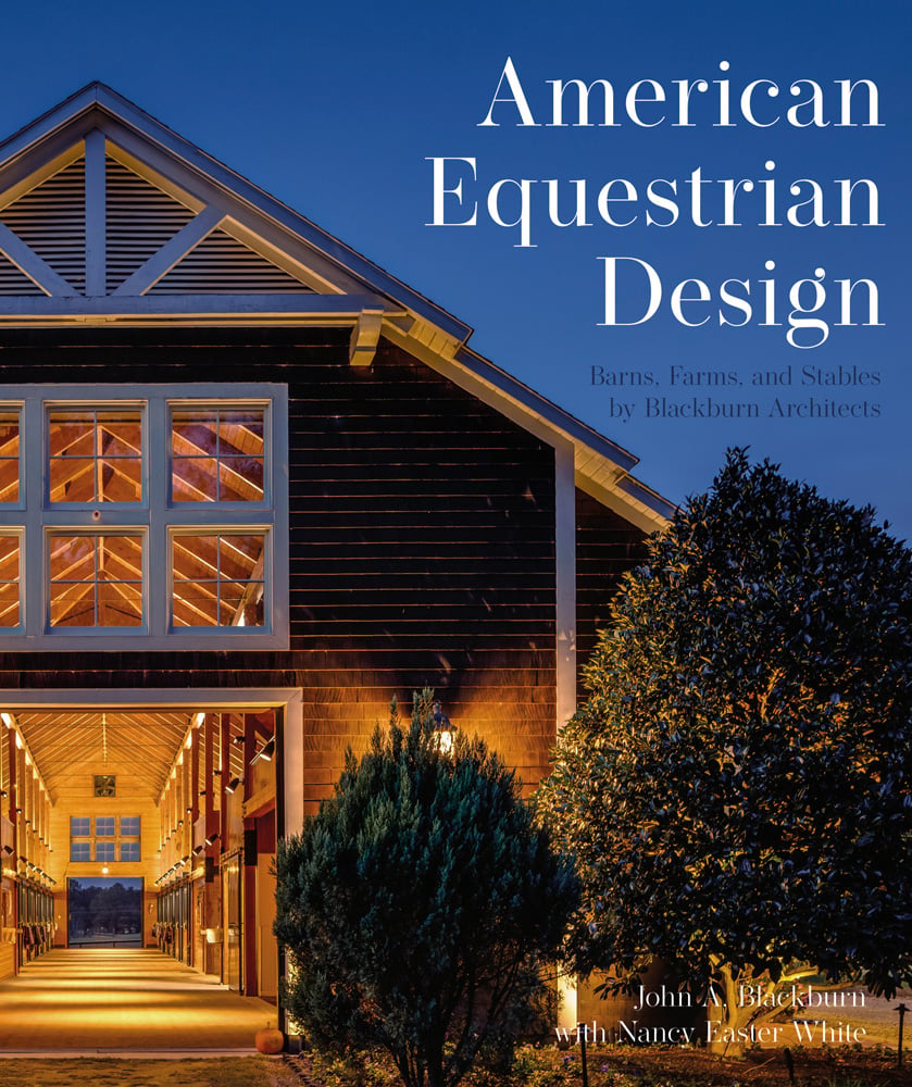 Horse stable entrance 2 trees in foreground, American Equestrian Design Barns, Farms, and Stables by Blackburn Architects in white and blue to upper right.